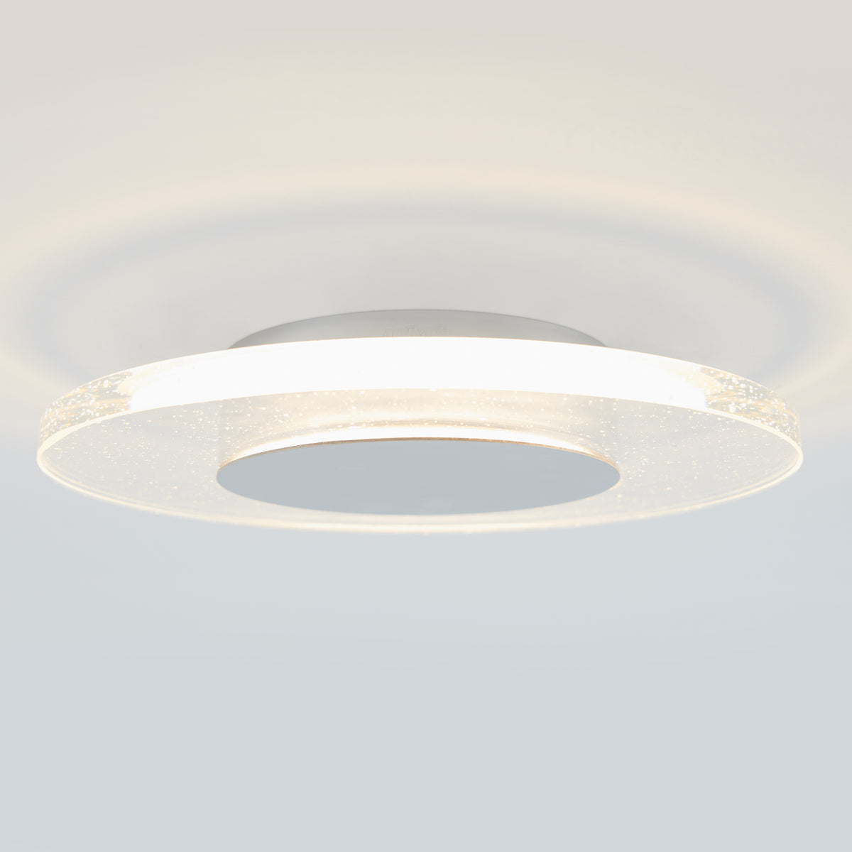 The Artika Essence Disk LED flush mount features a glowing white ring and central disc for a soft halo effect, delivering contemporary elegance and modern style to any room with its ceiling-mounted design.