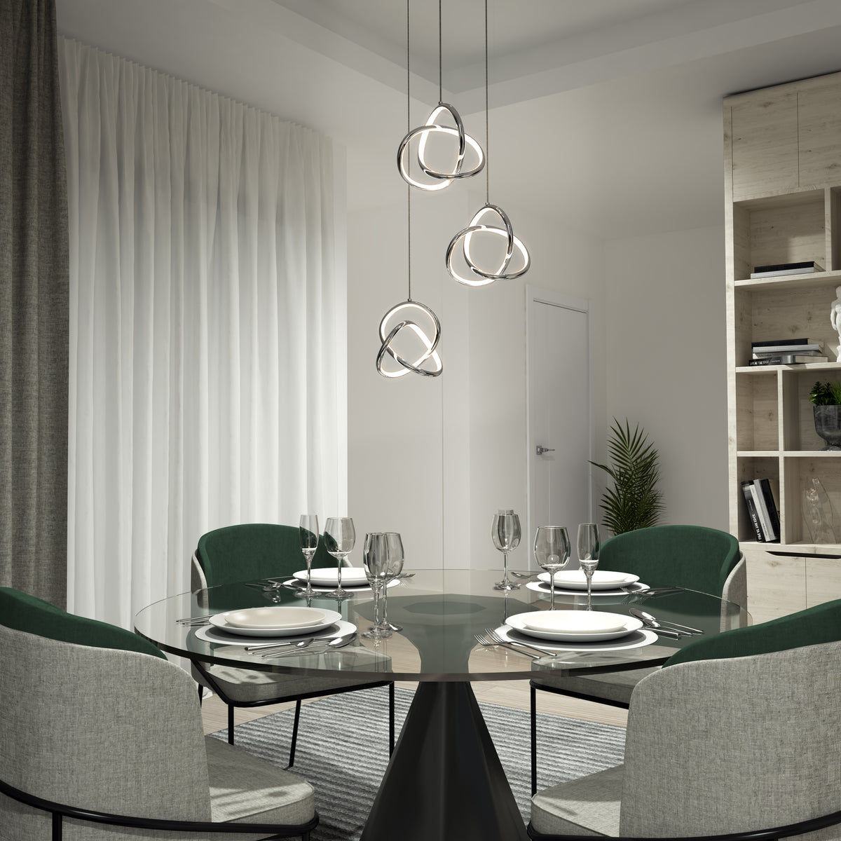 A modern dining room with a round glass table set for four, green upholstered chairs, sheer curtains, a light wood shelving unit with decor, and the Artika Zephyr 3-light LED pendant as stylish modern lighting.