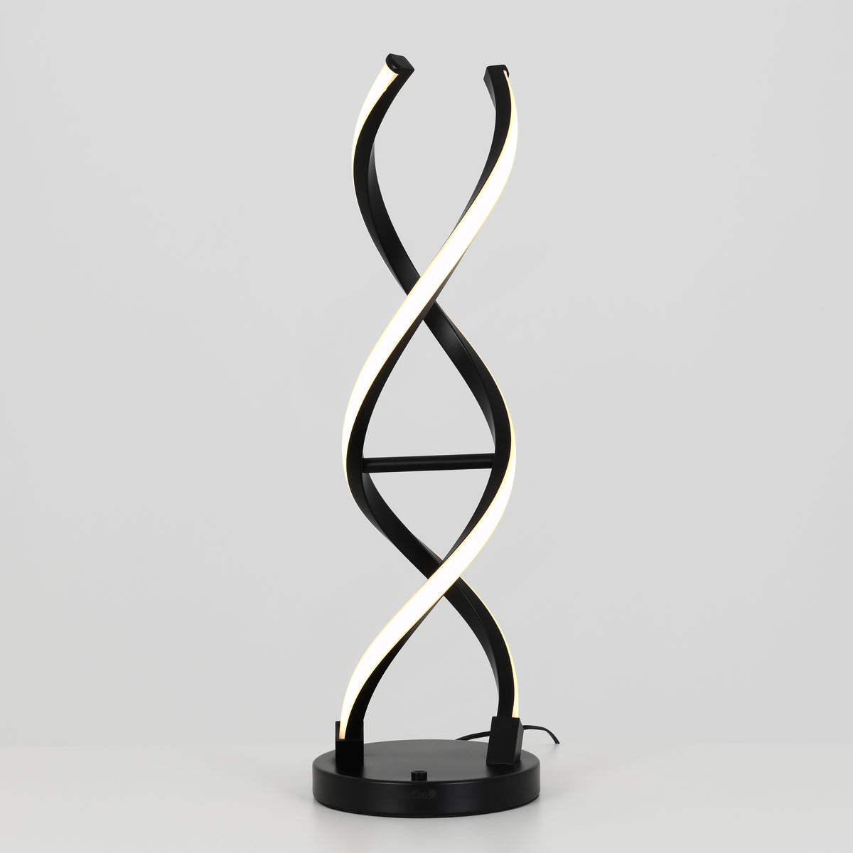 The Artika Swirl LED table lamp features two intertwined, spiral-shaped dimmable LED strips resembling a DNA double helix, set on a black and chrome base against a plain gray background.
