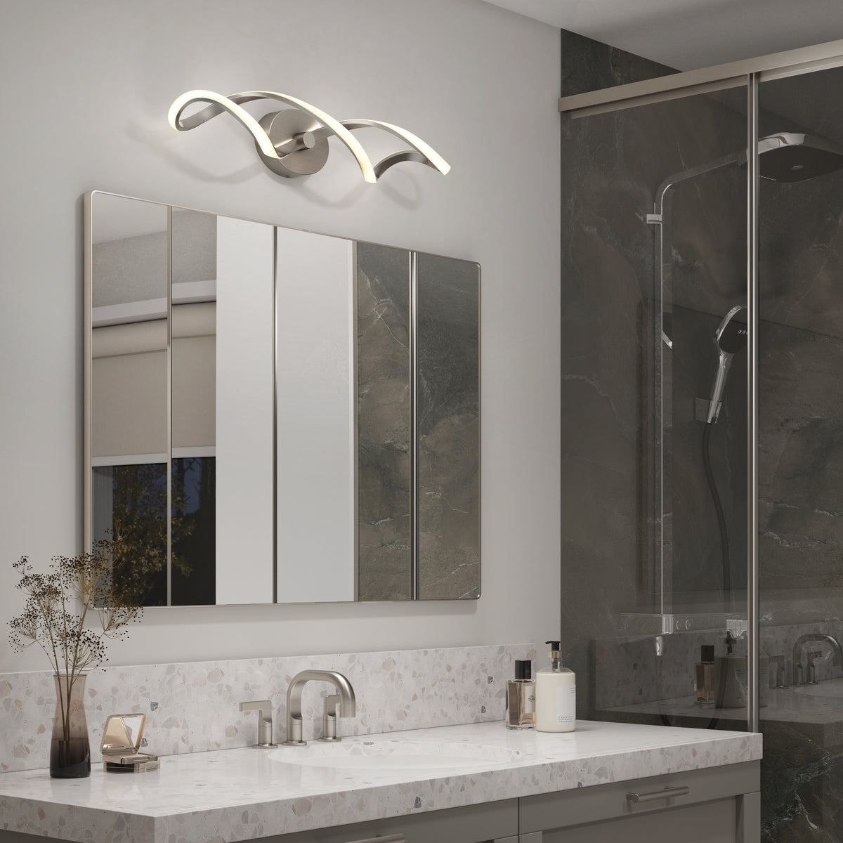 Modern bathroom with a marble countertop, sleek faucet, mirrored cabinet, decorative vase, soap dispensers, and the Artika Swirl LED bathroom vanity light above the mirror; glass shower in the background.