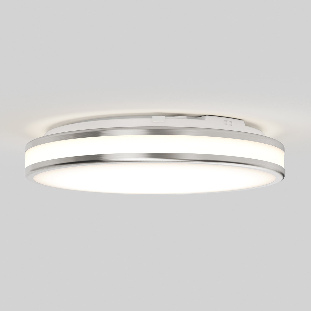 The Artika Hemisphere 15 in. LED flush mount light features sleek silver trim and 5 selectable color temperatures, offering bright, adjustable white light—perfect for modern bathroom lighting on a plain white ceiling.