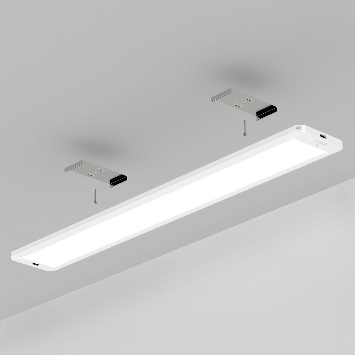 The Artika Maestro under cabinet LED light 3CCT is mounted on a gray ceiling, with two metal brackets and screws visible above it, demonstrating the installation process.
