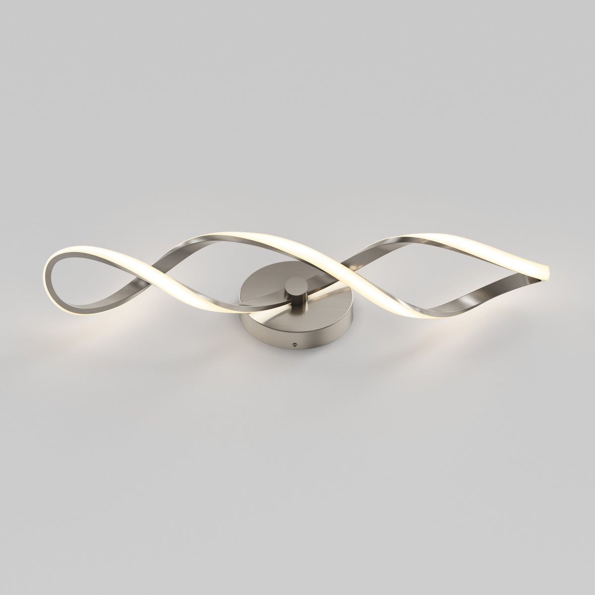 The Artika Swirl LED bathroom vanity light features two intertwined wavy metallic arms, with one arm emitting a soft white glow, displayed against a plain light gray background.