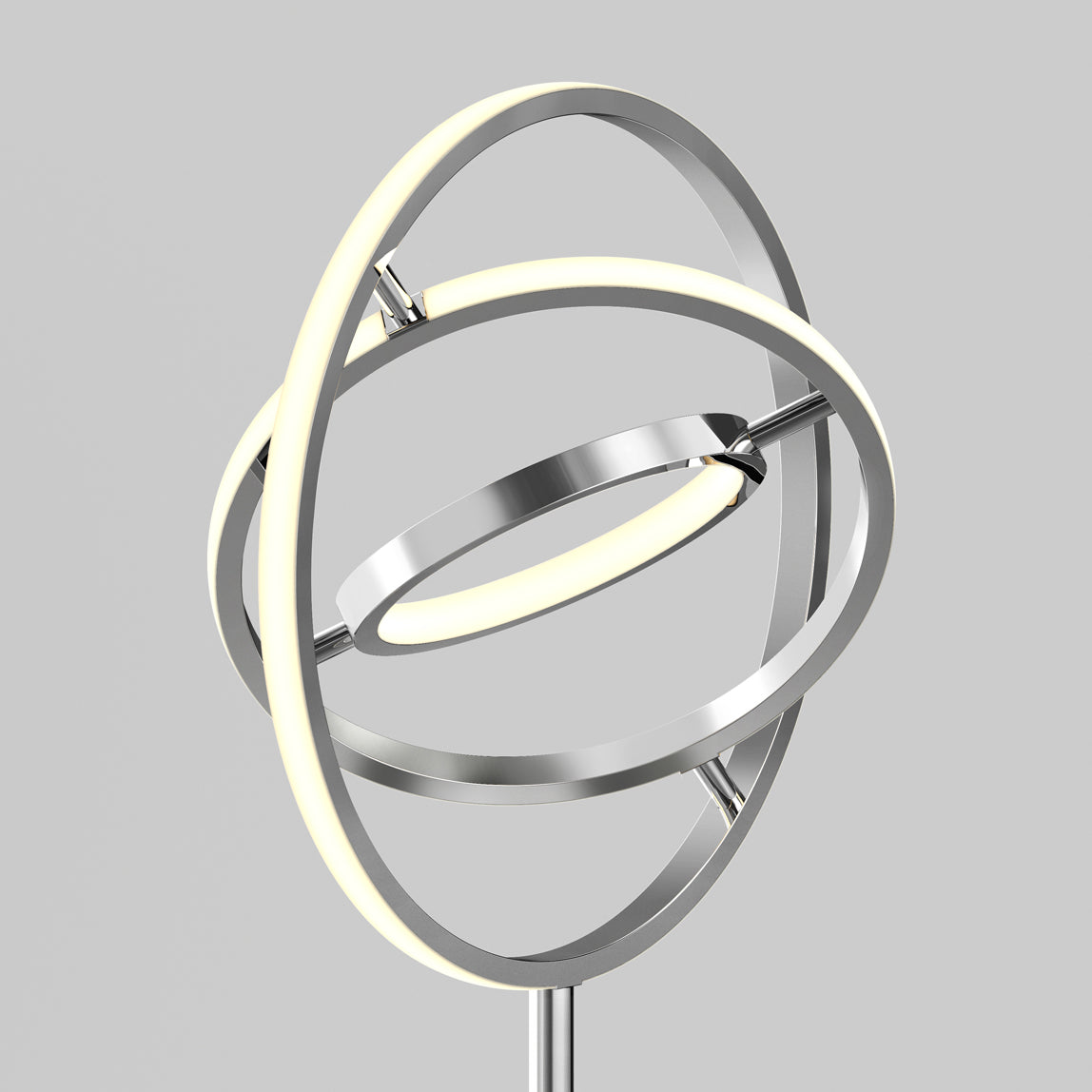 The Artika Pivot modern LED floor lamp 3 CCT showcases three intersecting metallic rings with built-in LEDs, forming a geometric, sculptural design set against a plain gray background.