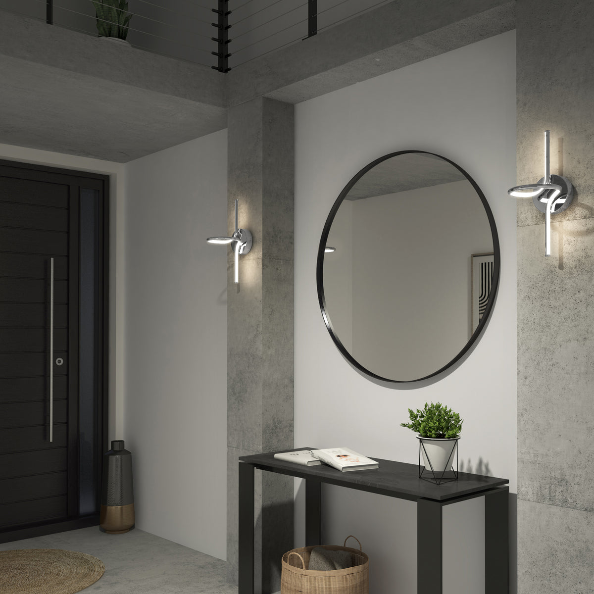 Modern entryway with a round wall mirror above a black console table, decorated with a potted plant and books. Concrete walls feature two Artika Swirl LED Sconces, and a basket sits below the table.