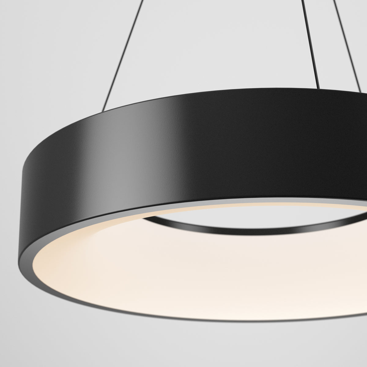 The Artika Aiden LED pendant light features a minimalist black circular design, suspended by thin wires, casting a soft, diffused glow downward against a plain white backdrop.