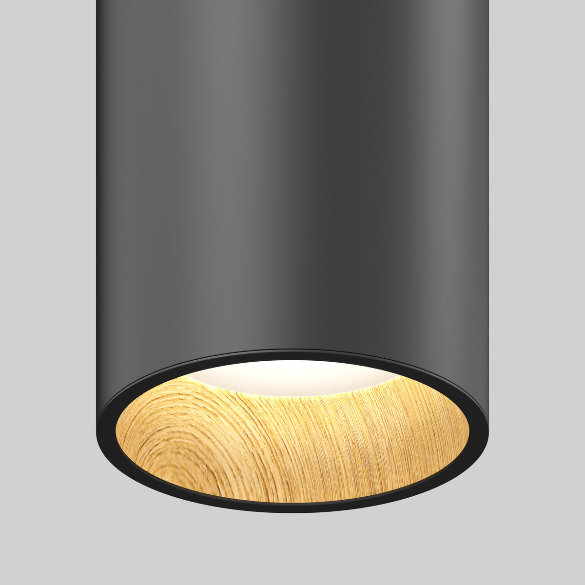 A close-up of the Artika Alton mini LED pendant light 5 CCT shows its modern cylindrical design with a matte black finish and light wood-textured inner rim, emitting a soft white glow against a plain gray background.