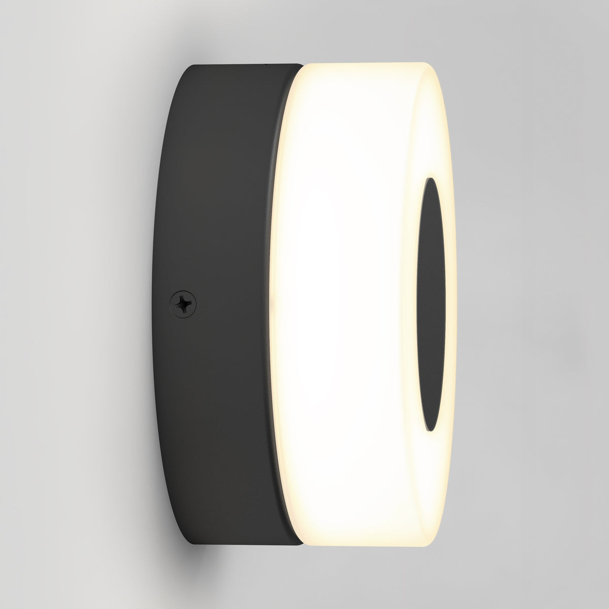 The Artika Ludwig modern LED indoor-outdoor wall light 5CCT features a black base and a circular frosted white cover, mounted on a light gray wall.