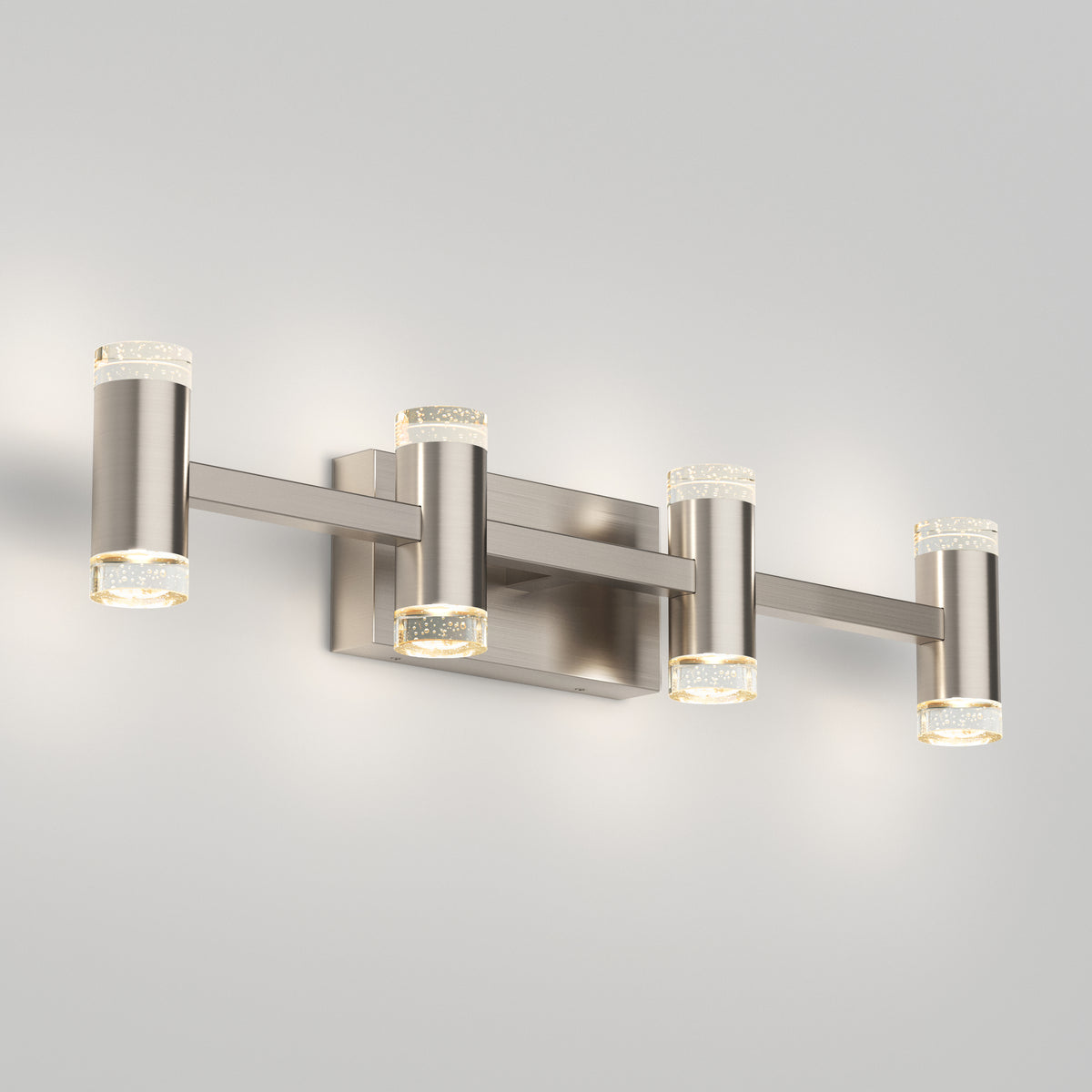 The Artika Mist modern LED bathroom vanity light 5 CCT features four cylindrical lights, a brushed nickel finish, and frosted glass accents—ideal for bathrooms, offering adjustable colour temperature and a soft glow against light gray walls.