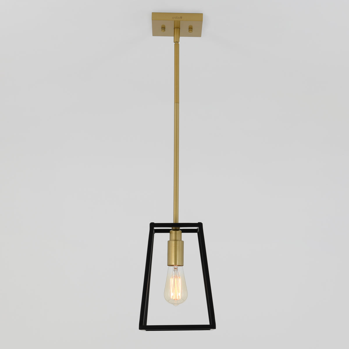 The Artika Carter 1-light pendant features a brass rod and square ceiling mount, with a single exposed bulb enclosed in a trapezoidal black metal frame, offering modern style against a plain white background.