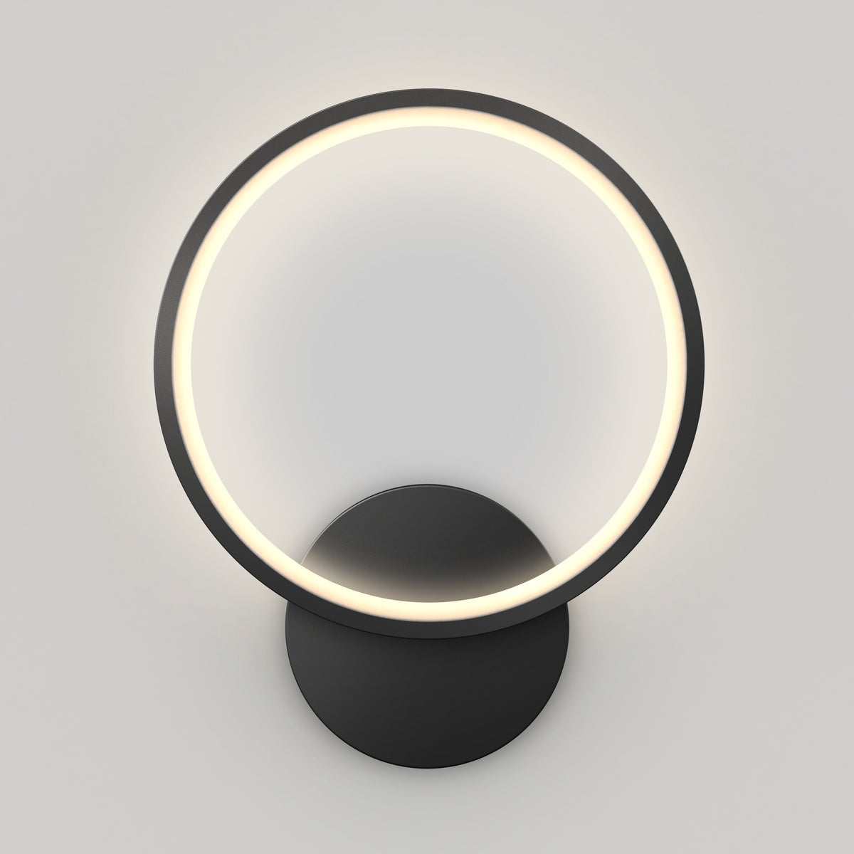 The Artika Solis modern LED indoor-outdoor wall light 5 CCT features a circular LED ring on a round black base, delivering a soft, even glow against a light gray wall.