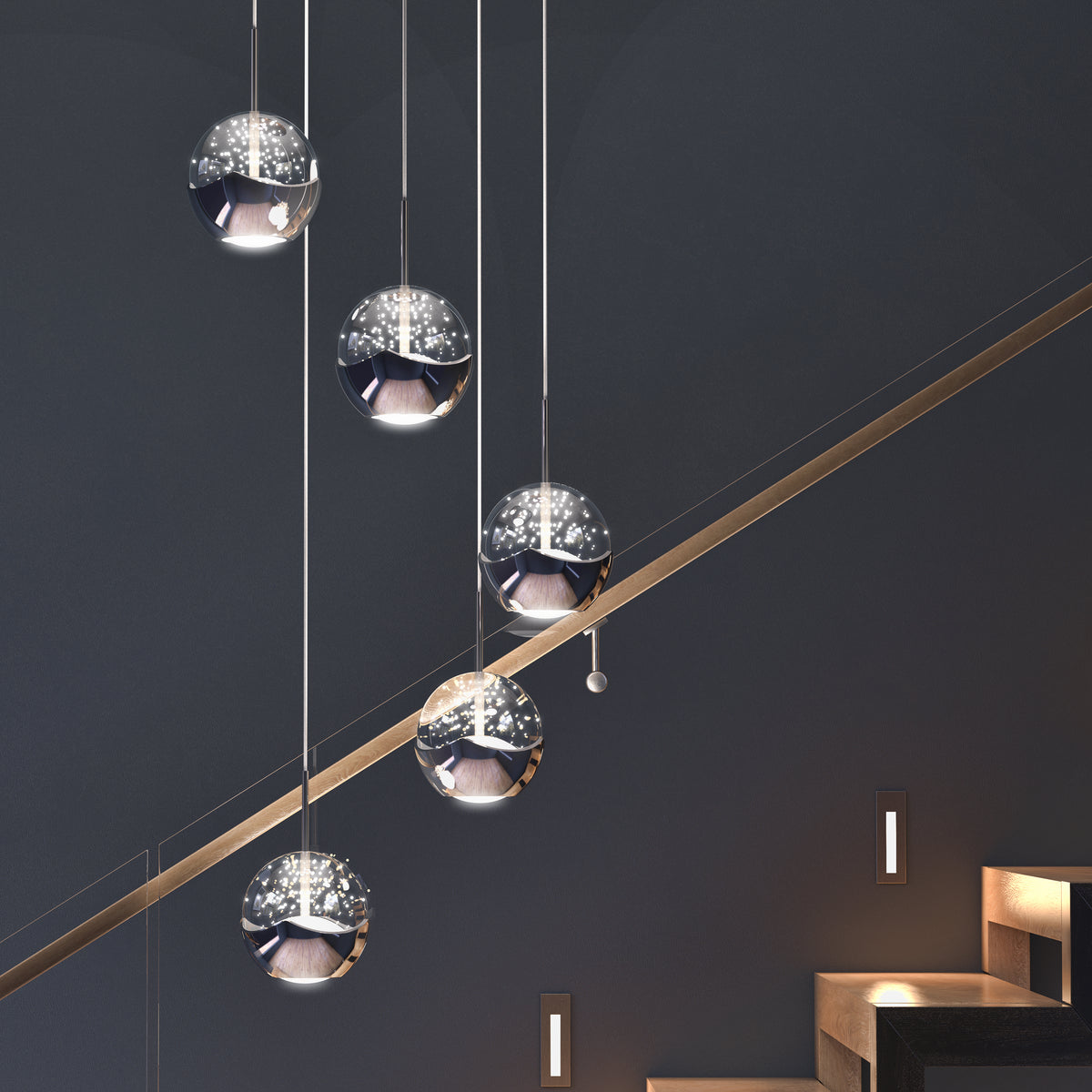 The Artika Oracle modern 5-light LED pendant features reflective, spherical shades that emit a soft, star-like glow above a staircase with dark steps and walls illuminated by small rectangular lights.