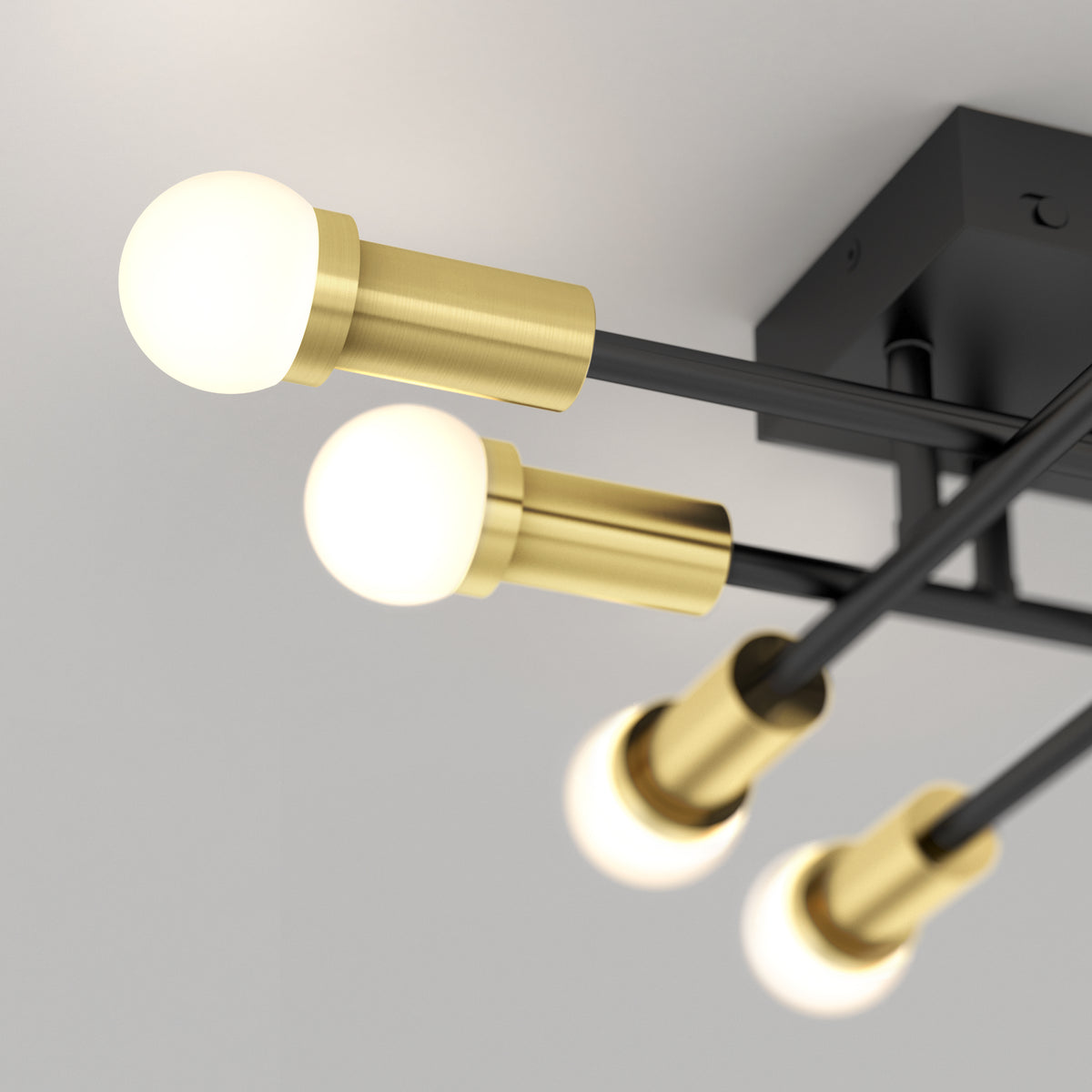 The Artika Aristo LED flush mount 3 CCT features four round bulbs on black and brass arms with adjustable color temperature.