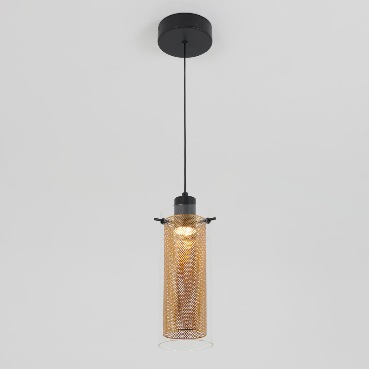 The Artika Oxion 1-light LED pendant features a cylindrical glass shade with a perforated metal inner cylinder, suspended from a black cord and ceiling mount, shown against a plain white background.
