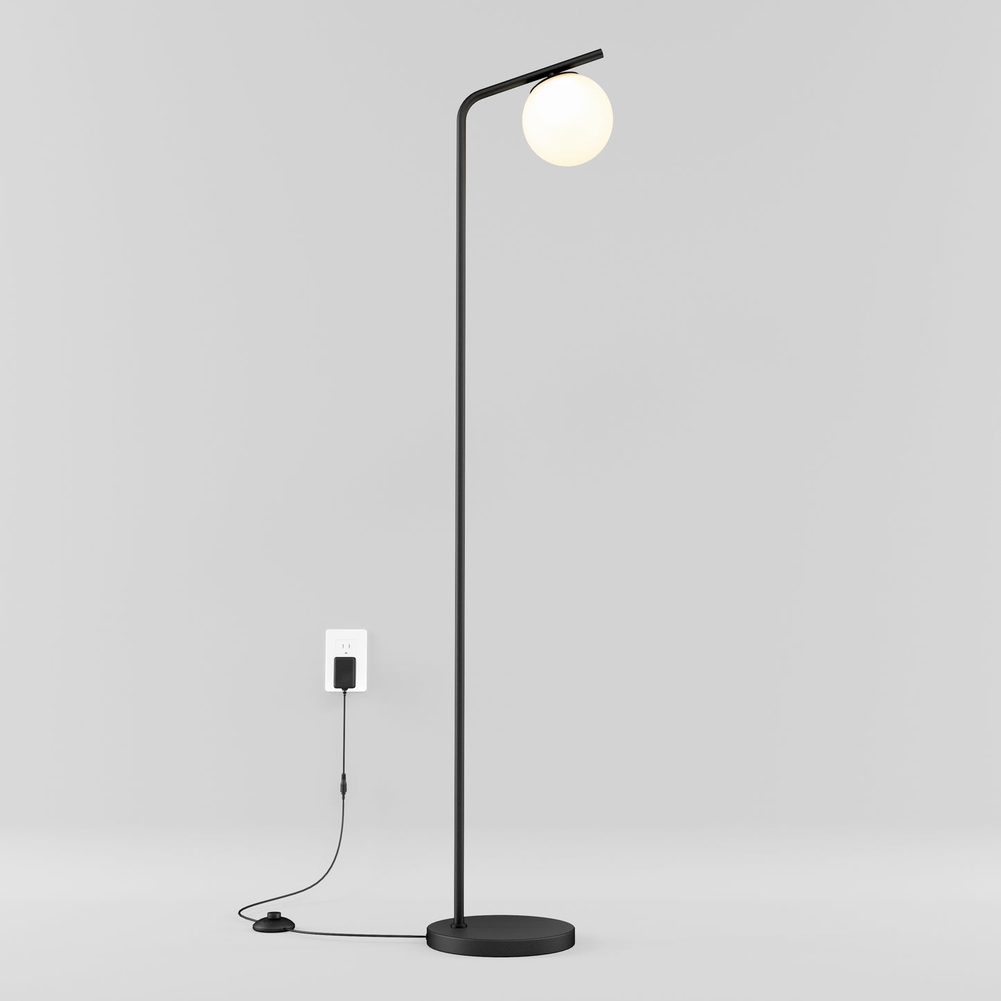 The Artika Clayton dimmable LED modern mid-century floor lamp in black stands on a minimalistic white background, featuring a round white bulb, visible cord, and floor switch.