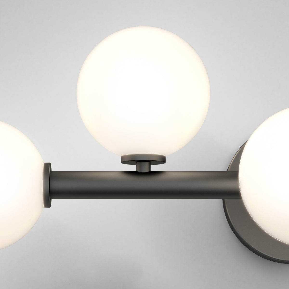 The Artika Bloom 27-in (69 cm) 3-Light Modern LED Vanity Light features frosted glass globes on a black fixture, ideal for bathroom lighting against a light gray wall.