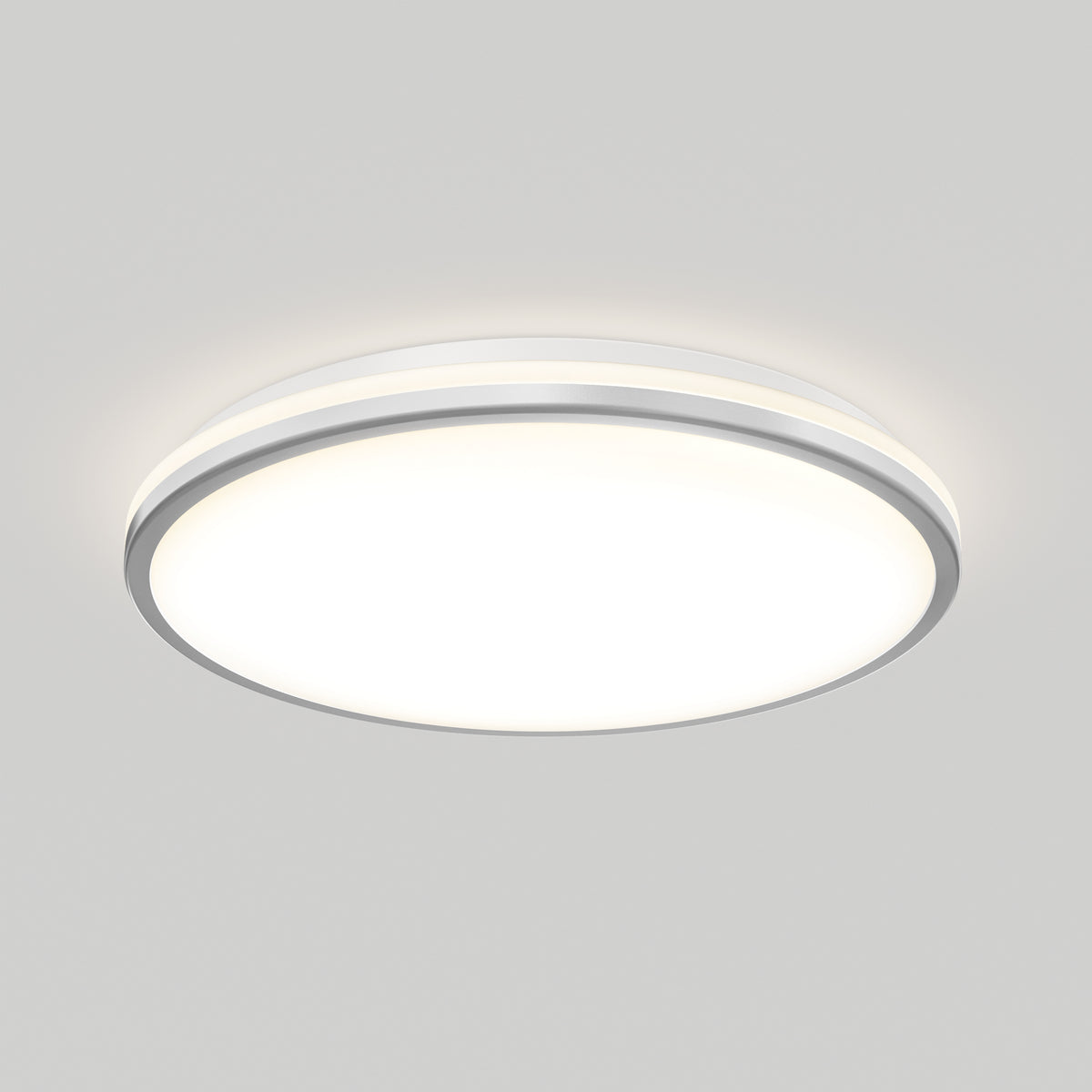 The Artika Macy 15 in. LED modern flush mount light with RGB Wifi is on, featuring a white diffuser and silver trim.