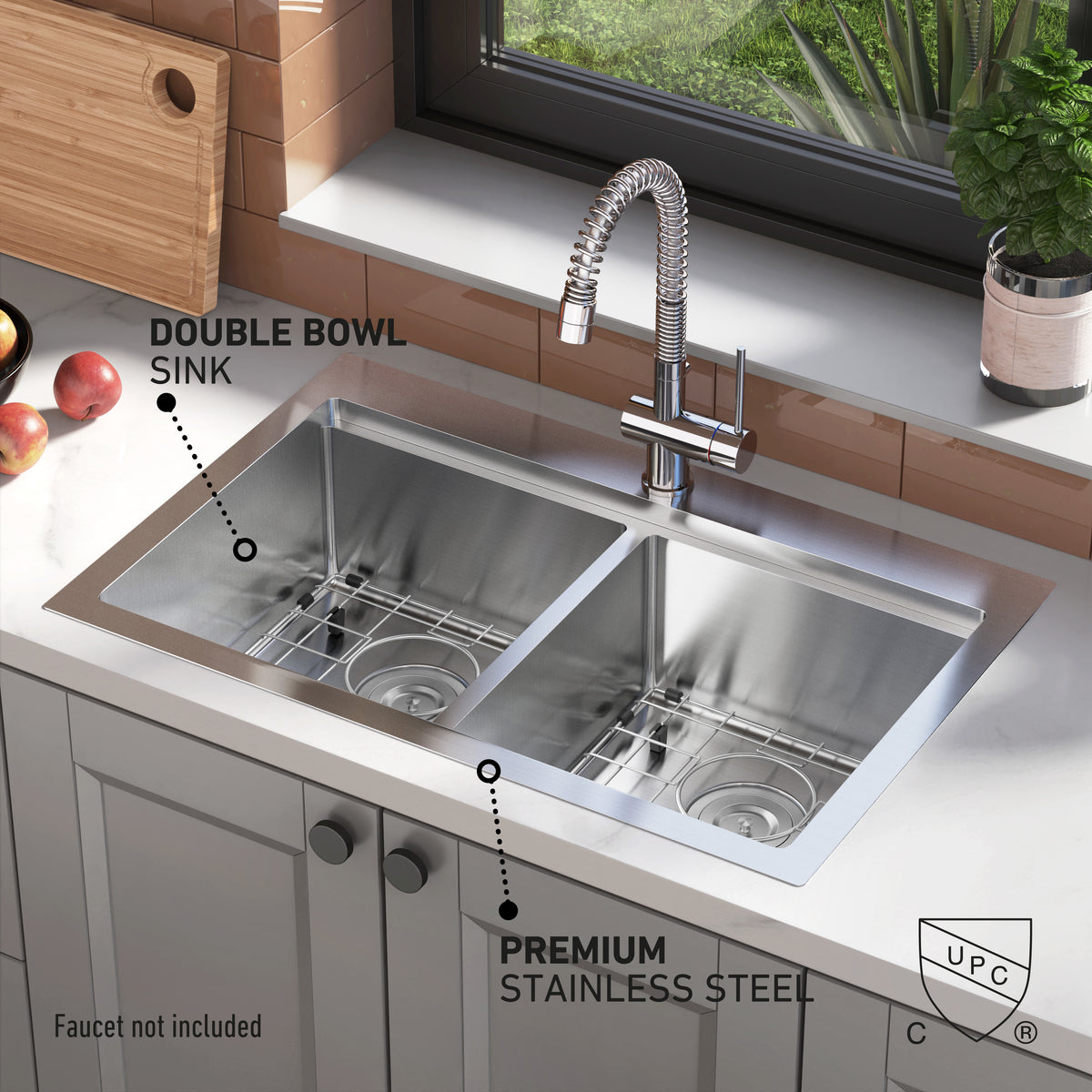 The Artika Newport double bowl stainless steel sink features two spacious bowls and a tall, flexible faucet. Labels showcase its premium stainless steel construction. Apples and a plant sit on the countertop near a window.