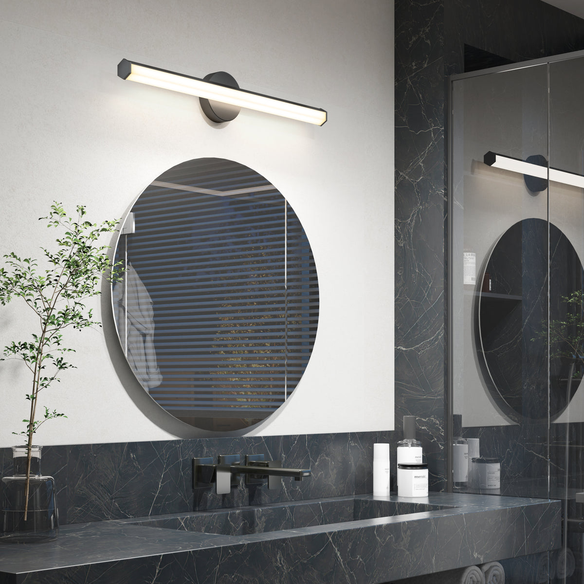 Modern bathroom with Artika Ewen LED vanity light above a round mirror, dark marble countertop, and small potted plant.