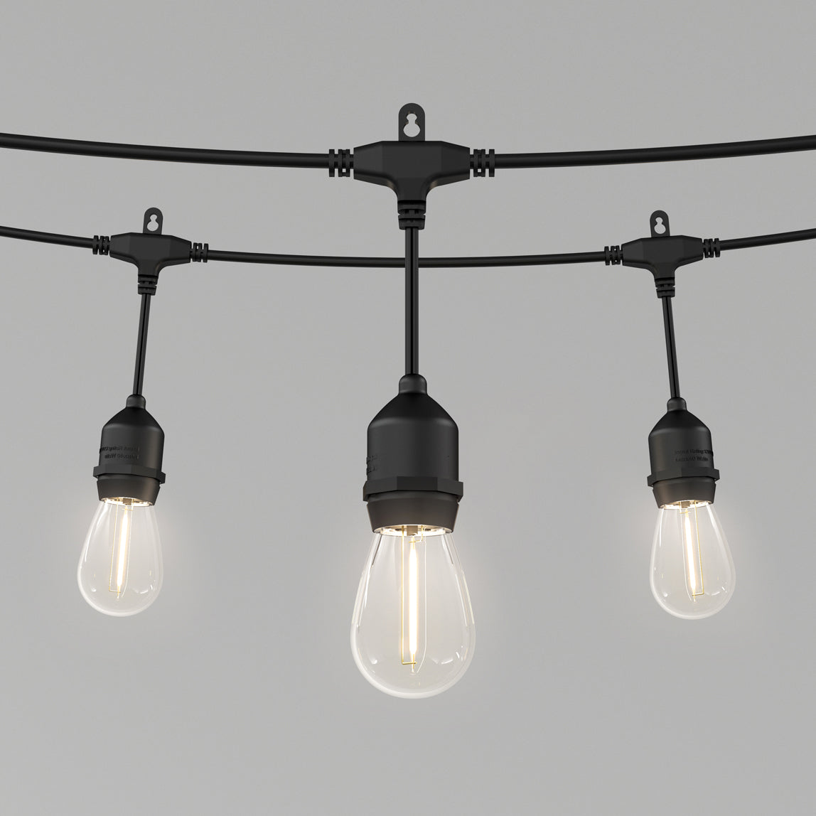 Three Blaze 20 LED Outdoor Solar String Lights by Artika with exposed black LED bulbs hang from a wire against a plain gray background.