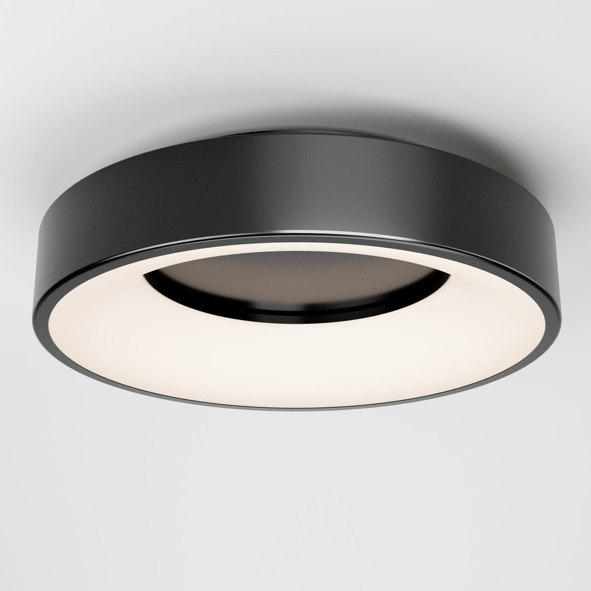 The Artika Aiden LED flush mount is a modern, circular black ceiling light with a wide white diffuser. Its minimalist, sleek design looks striking when mounted on a white ceiling.