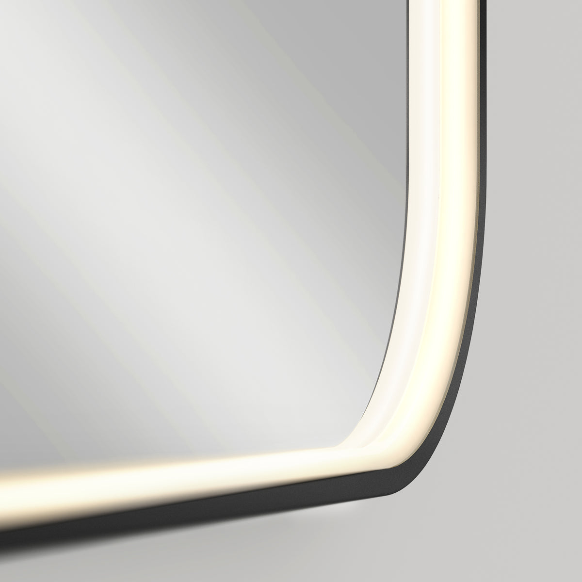 Close-up of the Royce Dimmable LED Mirror by Artika, featuring rounded edges, built-in LED light strip with 3 adjustable colour temperatures, and a soft white glow. Can be mounted horizontally or vertically against a neutral background.