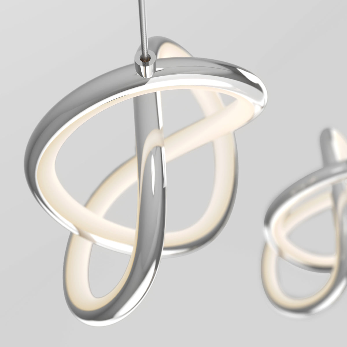 The Artika Zephyr 3-light LED pendant features intertwined metallic loops and integrated dimmable soft white light, creating a modern sculptural look when suspended from the ceiling against a neutral background.
