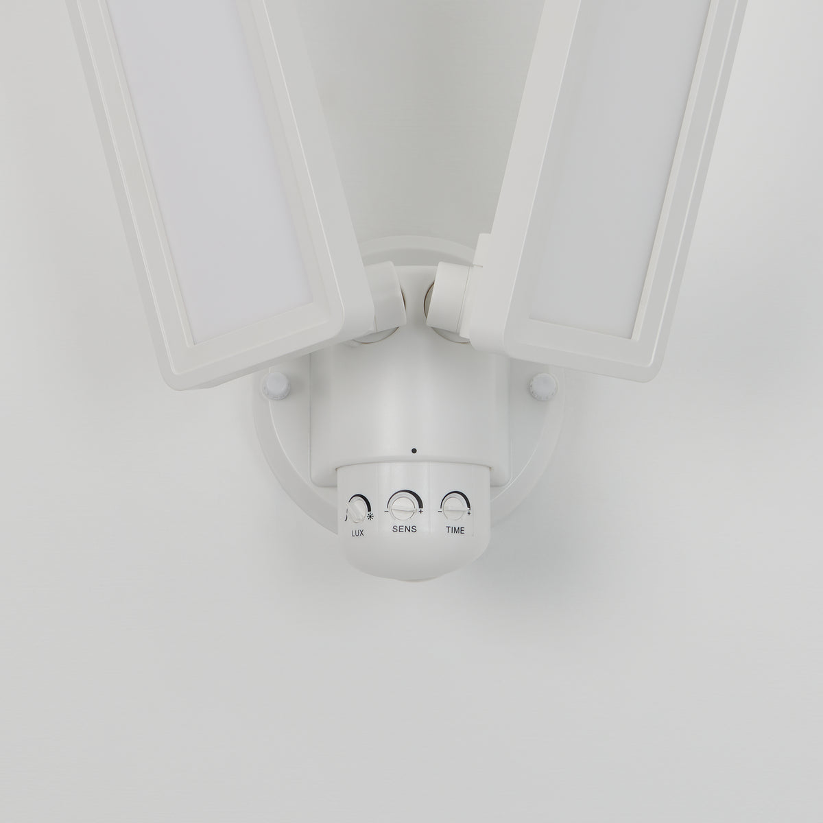 The Artika Sentinel outdoor Flat Panel Security light is a white LED floodlight with two adjustable rectangular panels and three control dials (LUX, SENS, TIME), mounted on a white wall.