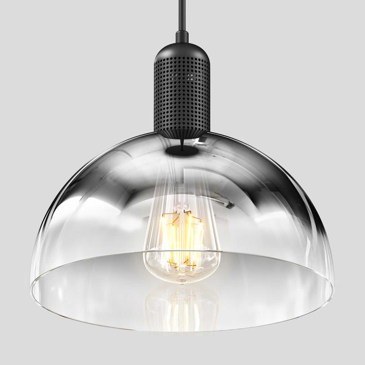 The Artika Nella Pendant without Bulbs features a clear glass shade and black perforated metal fixture, showcasing a visible filament bulb, all set against a plain gray background.