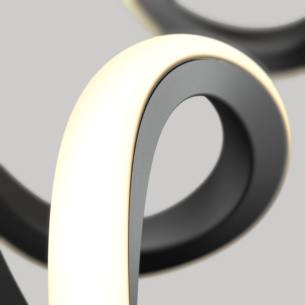 A close-up of the Artika Mini Swirl LED pendant light reveals its smooth, looping black design with a glowing white edge, set against a plain gray background for a modern, abstract look.