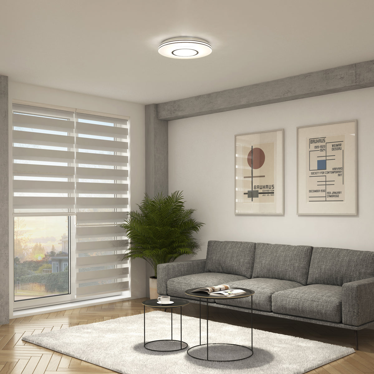 Modern living room with a gray sofa, wall art, and Artika Horizon 13 in. LED flush mount light 3 CCT near window blinds.