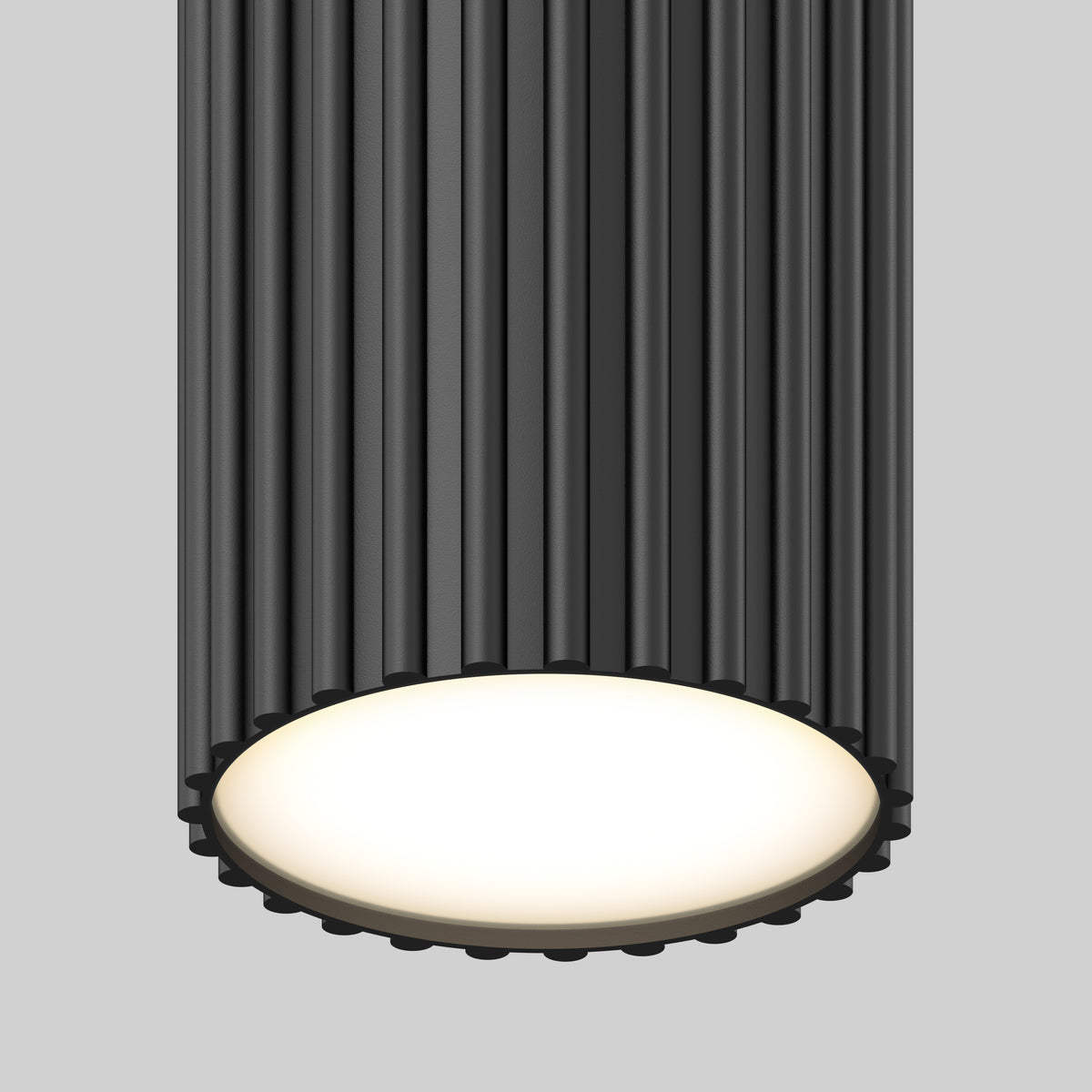 A close-up of the Artika Groove LED modern pendant light 3 CCT, featuring a ribbed dark gray cylindrical exterior and a glowing matte white bottom, set against a plain gray background.