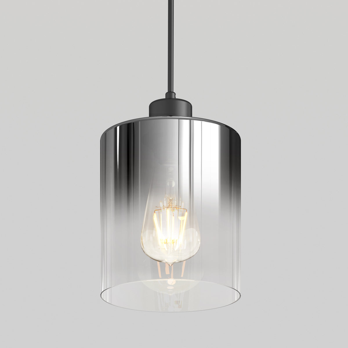 The Artika Haze pendant light features a clear cylindrical glass shade with an exposed bulb, suspended from a black cord, set against a plain light gray background.
