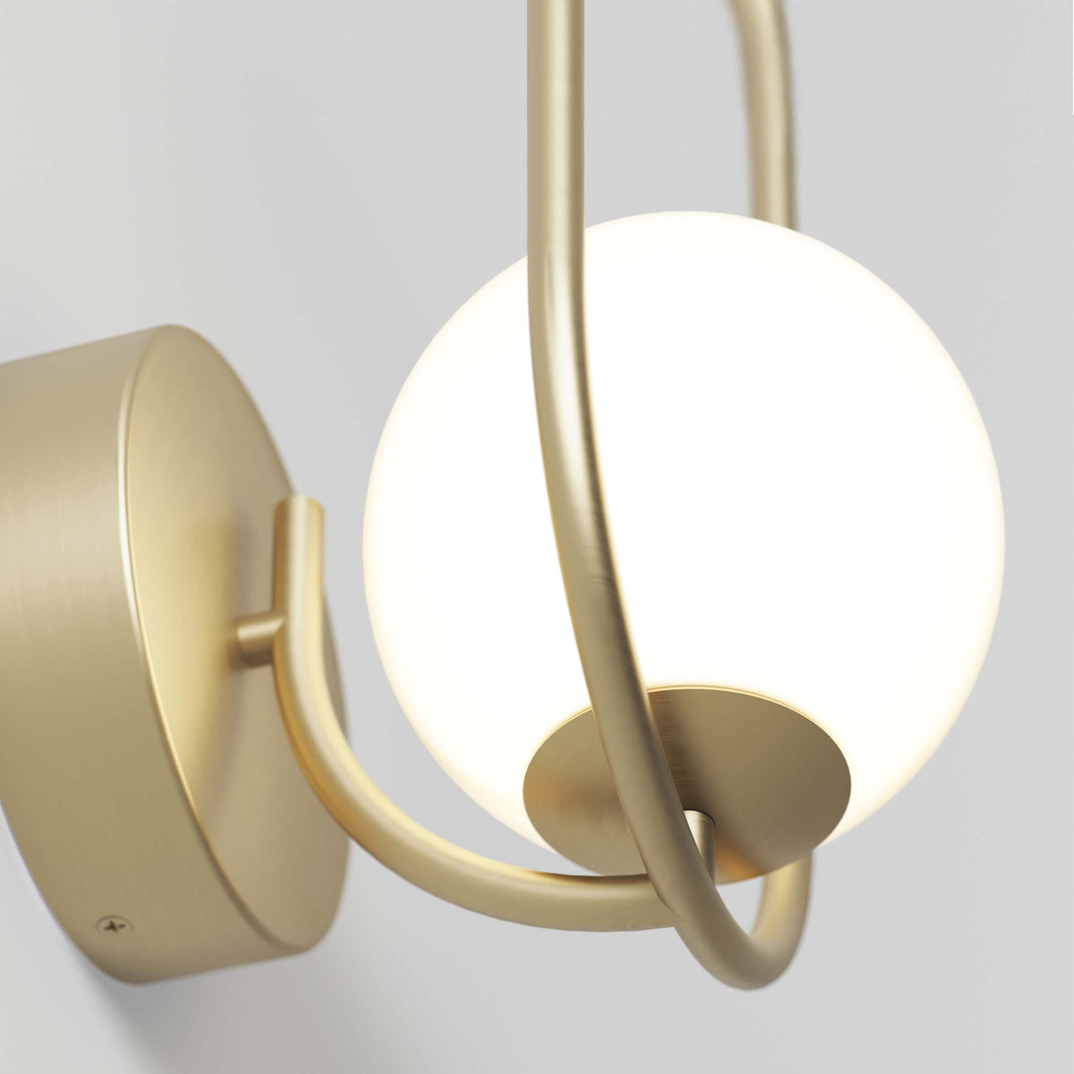 A close-up of the Artika Bloom LED Sconce 3 CCT, featuring a round frosted glass globe and brushed gold frame, mounted on a light-colored wall.