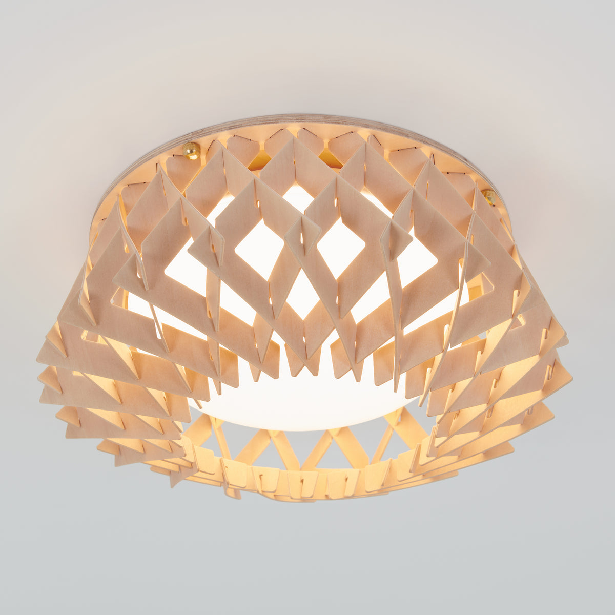 The Artika Kiran 13 in. modern LED flush mount light features a geometric wooden lattice design around a round white light, offering 5 CCT options and mounting seamlessly on a white ceiling.