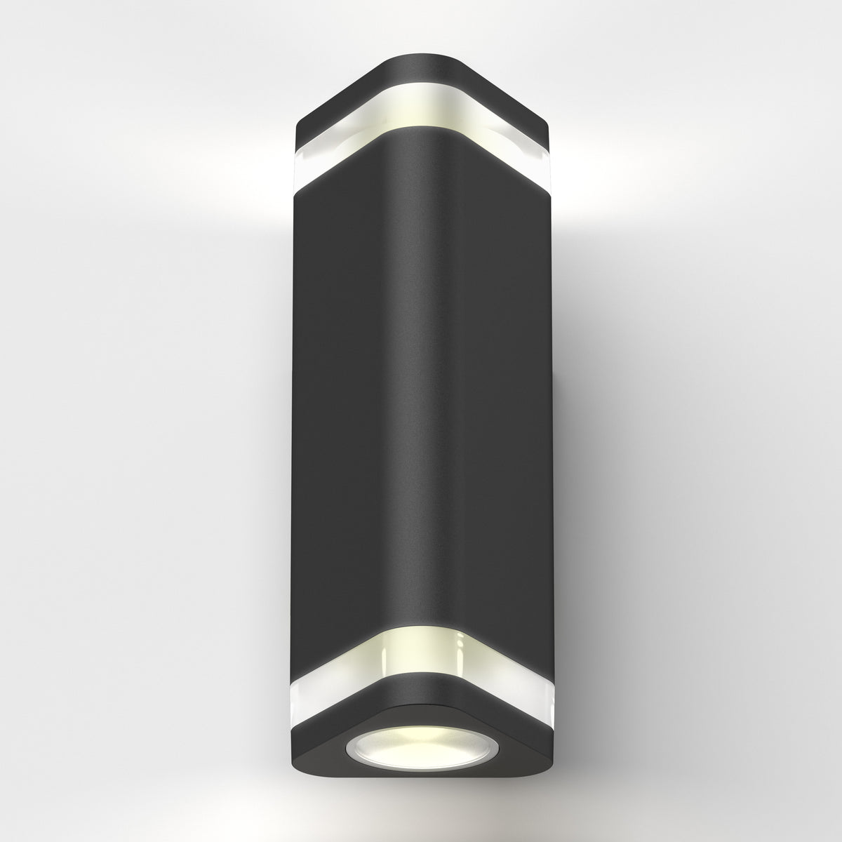The Trygon indoor-outdoor wall light by Artika is a modern black sconce with a cylindrical shape and white accent bands, mounted on a white wall, emitting light from both the top and bottom.
