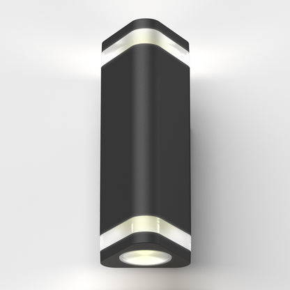 The Trygon indoor-outdoor wall light by Artika is a modern black sconce with a cylindrical shape and white accent bands, mounted on a white wall, emitting light from both the top and bottom.