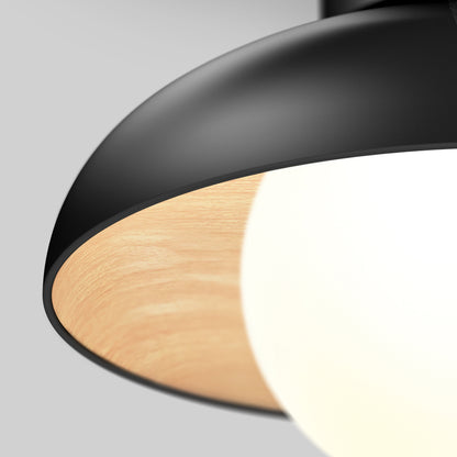 Close-up of the Artika Boden LED flush mount light 5 CCT, featuring a black outer shade, wooden inner ring, and glowing white bulb against a plain light gray background.