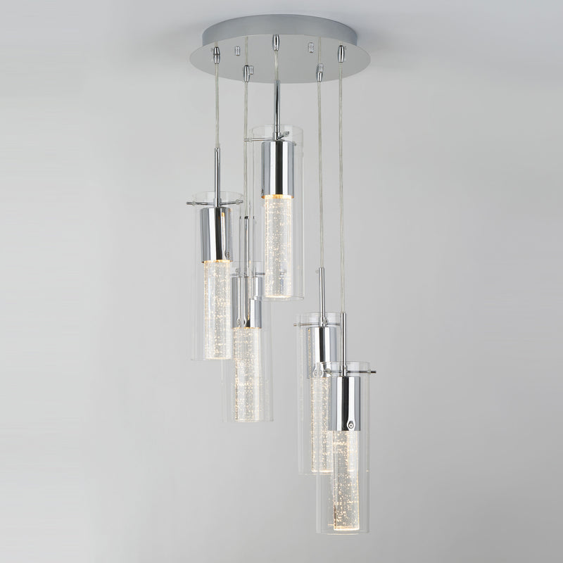 The Artika Bubble Swirl 5-light pendant features five cylindrical glass pendants with bubble details, suspended at varying heights from a round silver base, creating a soft, warm glow.