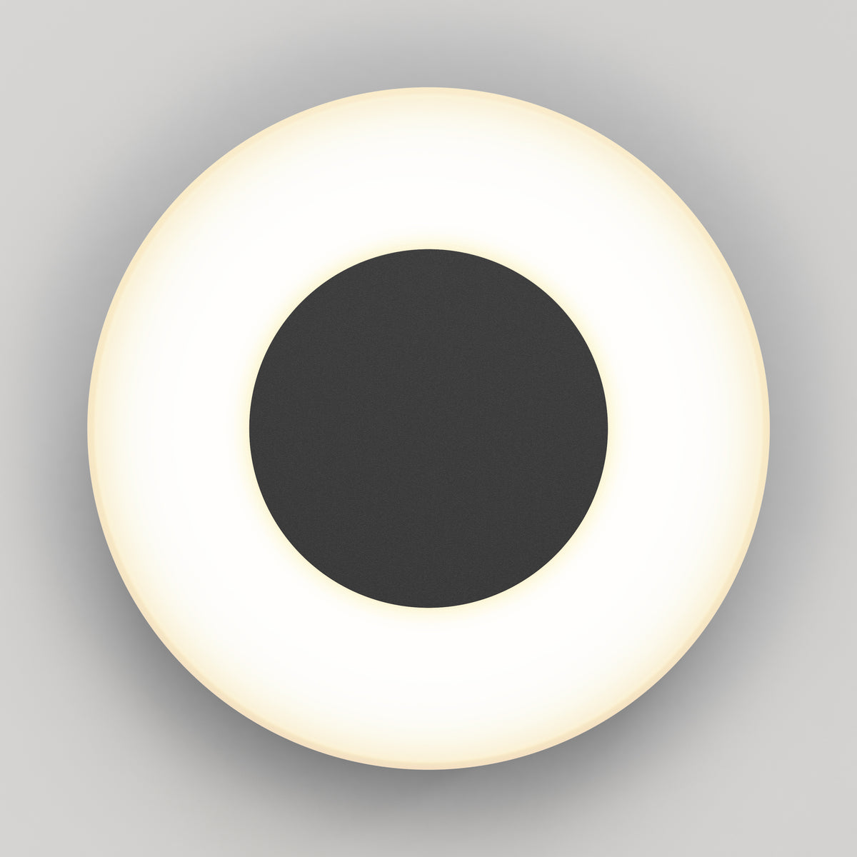 The Artika Ludwig modern LED indoor-outdoor wall light 5CCT features a black central disk encircled by a glowing white ring, shown from above against a plain light gray background.
