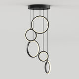 A modern ceiling light fixture featuring five circular LED rings of varying sizes, suspended at different heights from a round black base against a plain white background.