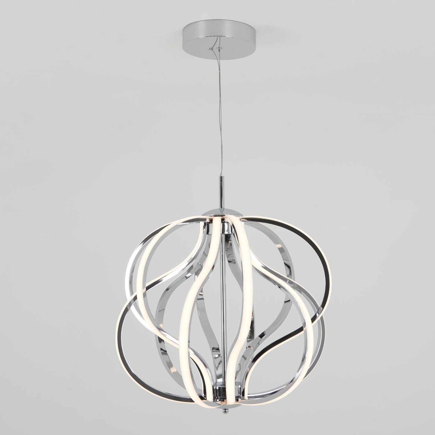 The Artika Meridian LED pendant light features curved chrome-finished metal bands with integrated LED strips, suspended from the ceiling by a thin wire, set against a plain light gray background.