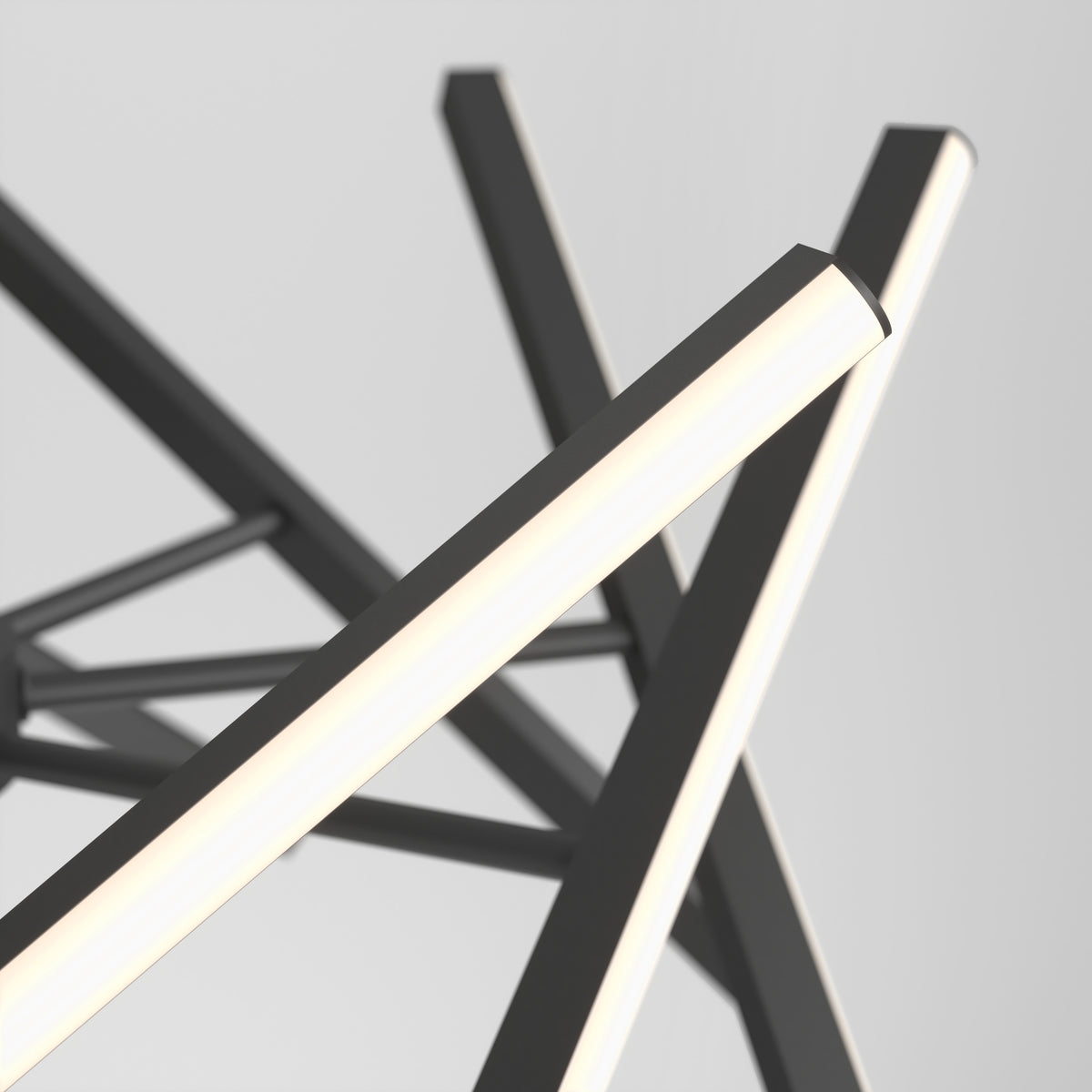 Close-up of the Artika Malibu LED pendant light 3 CCT, featuring intersecting black metal rods and glowing white LED tubes in an abstract, minimalist design, set against a plain light gray background.
