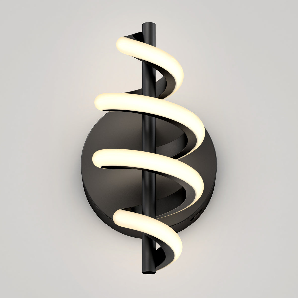 A modern wall sconce with a black circular base and a vertical black rod, around which a glowing, spiral-shaped LED light wraps, creating a sleek, contemporary look against a light gray background.