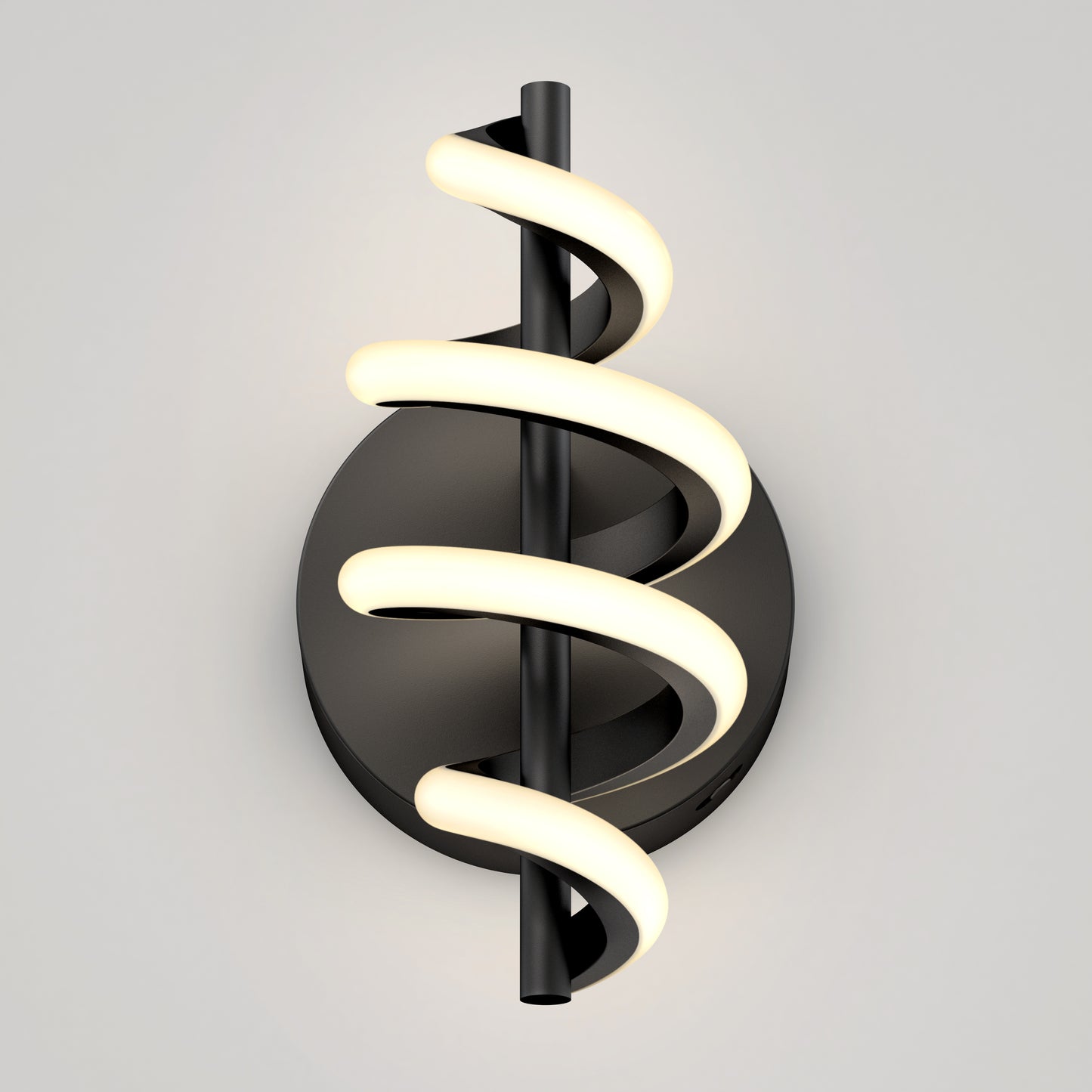 The Artika Chorus LED Wall Light features a black circular base and central vertical rod wrapped with a spiral LED strip, casting a soft, warm glow against a light gray background.