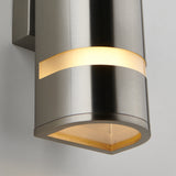 A close-up of a modern brushed metal wall sconce with a cylindrical shape, glowing warmly through two horizontal frosted bands, mounted on a white wall.