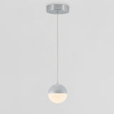 A modern pendant light with a round, two-tone shade hangs from the ceiling by a thin cord. The upper half is metallic silver, and the lower half is frosted and illuminated. The background is plain white.