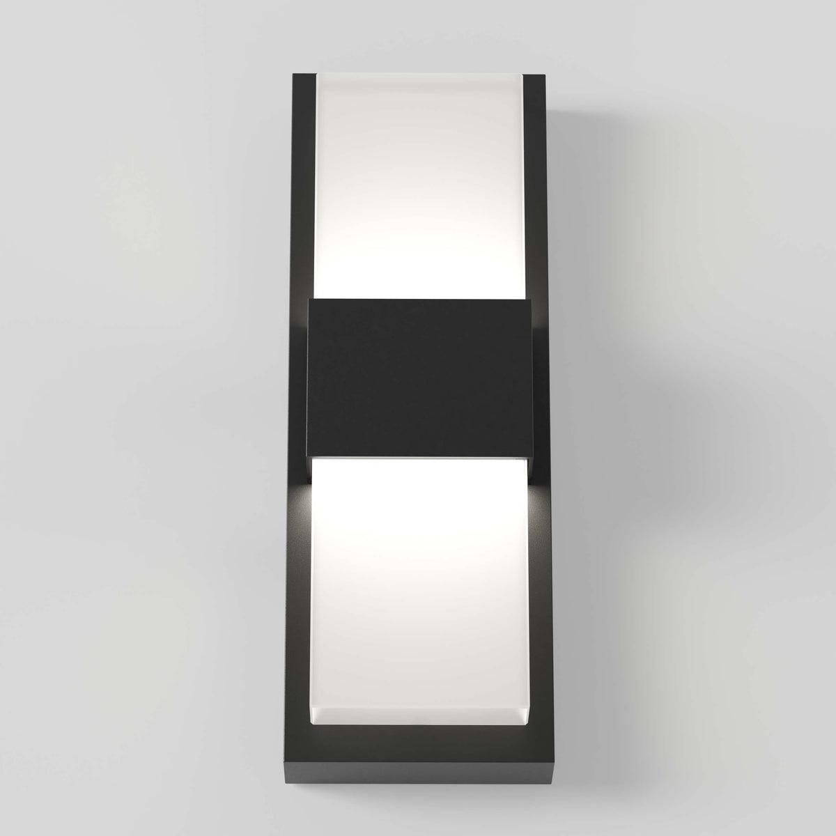 A modern rectangular wall sconce with a black frame and two frosted white panels, one on the top and one on the bottom, emitting a soft light, mounted on a light gray wall.