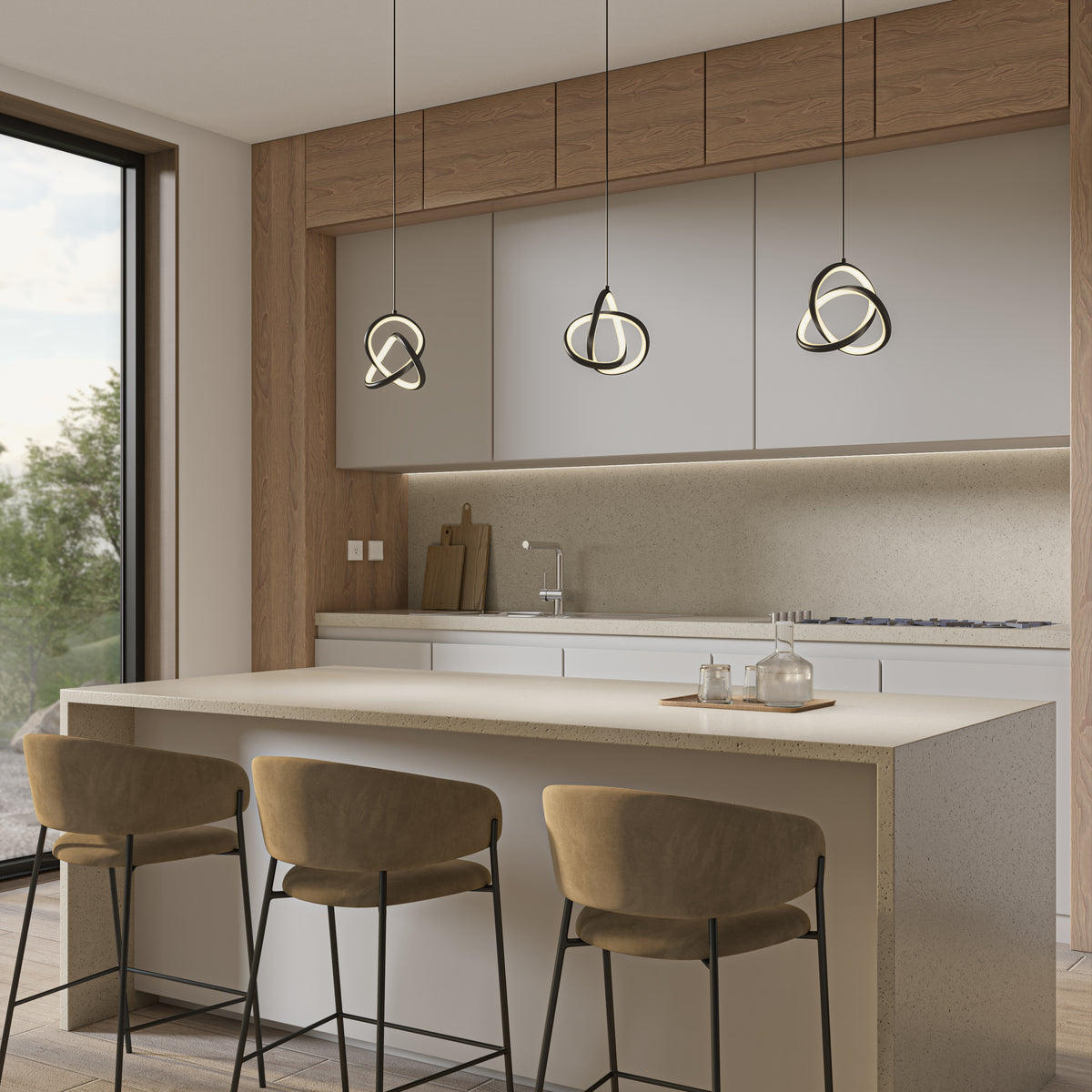 Modern kitchen with light wood and white cabinetry, three beige bar stools at a marble island, geometric pendant lights above, and large window with a view of greenery outside.