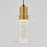 A modern pendant light with a cylindrical clear glass shade, a gold metal fixture, and an illuminated inner glass tube filled with small bubbles, hanging from a black cord against a light gray background.